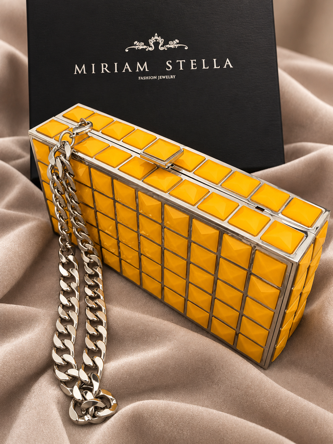 Clutch rigida gialla con motivo geometrico e catena argentata