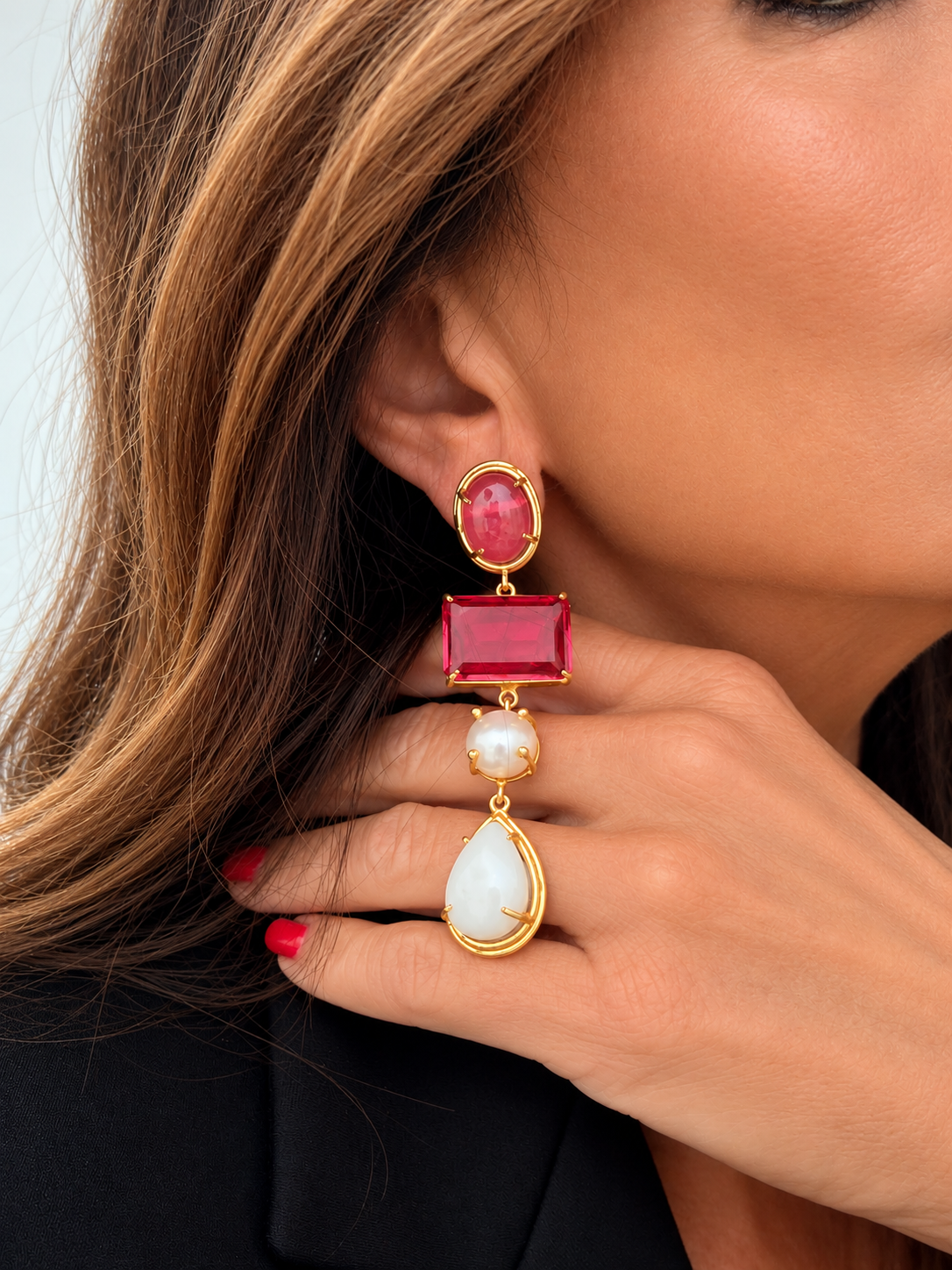 Orecchini pendenti fucsia con effetto perla e goccia bianca indossati