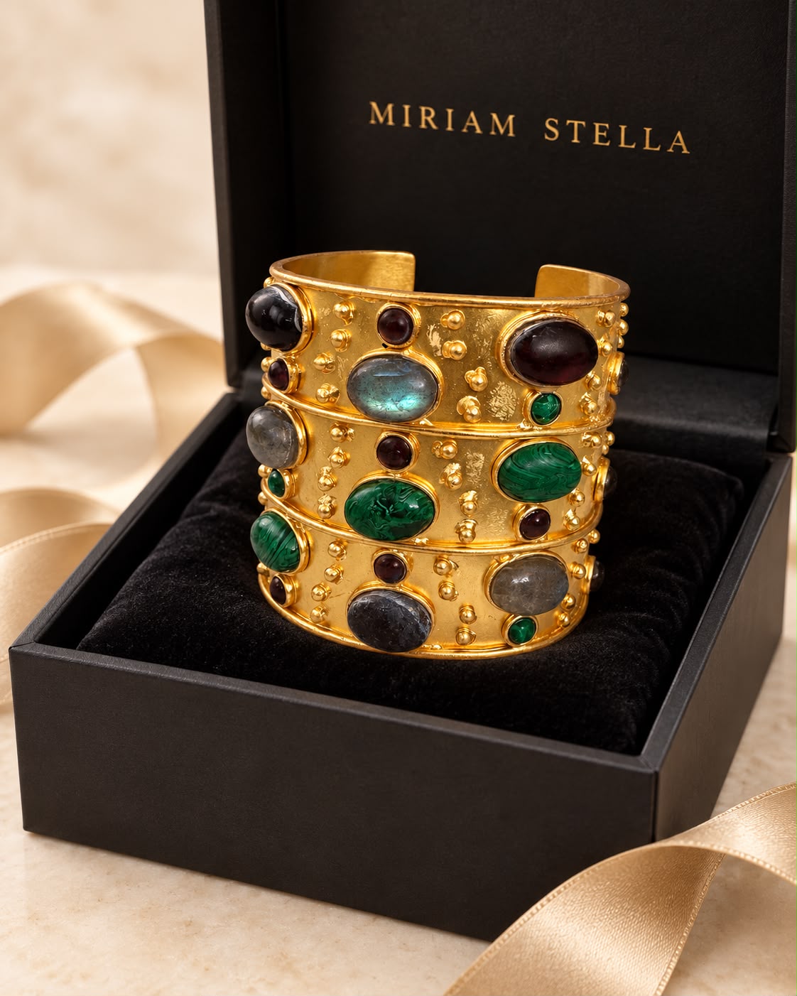 Bracciale rigido dorato con decorazioni nei toni scuri, verdi e grigi