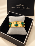Bracciale a fascia dorato con decorazioni ovali e tonde verdi venate