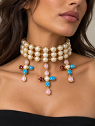 Choker a tre file effetto perla con tre croci multicolore e dettagli dorati indossato